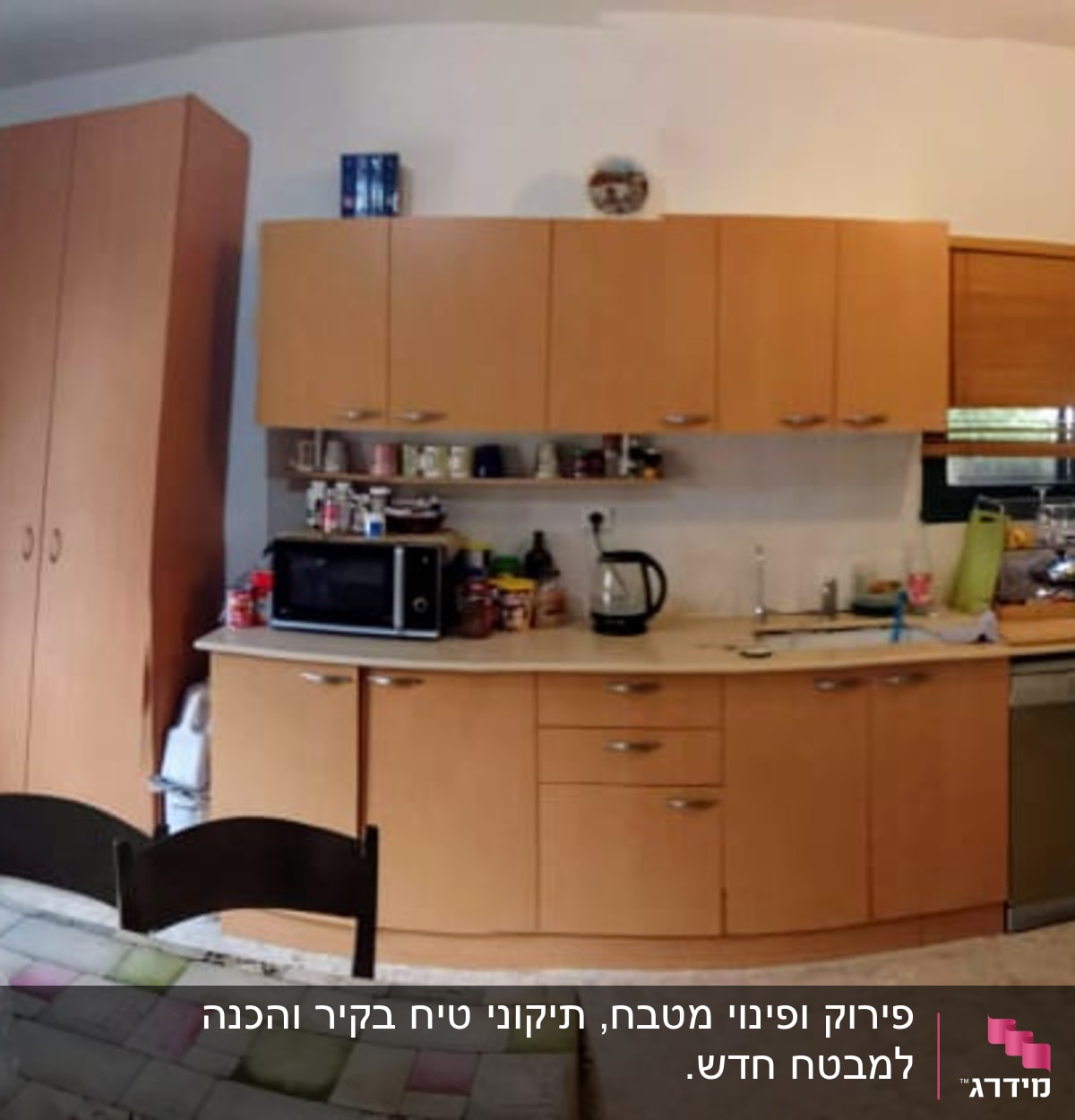 מטבח עם ארונות עץ, שולחן אוכל, ומכשירי חשמל